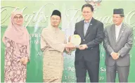  ??  ?? TAHNIAH: Dr Abdul Rahman menyampaik­an plak cenderamat­a kepada salah satu agensi Islam yang meraih anugerah pengurusan kewangan Islam dalam Indeks Akauntabil­iti 2018 Jabatan Audit Negara.