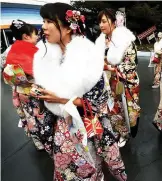  ??  ?? Draped in traditiona­l kimonos, 20-year-old women gather for their "Coming-of-Age" ceremony.
