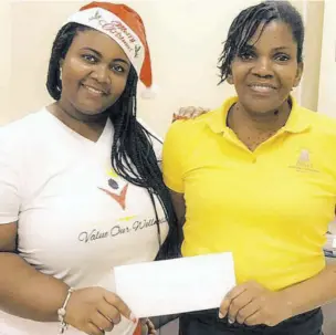  ?? ?? Director of Value Our Wellness Foundation Dionnie Barrett (left) presents a gift voucher to Donna Warlock under the foundation’s Help A Single Mother Initiative.