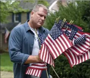  ?? BEN HASTY — MEDIANEWS GROUP ?? Air Force National Guard Maj. Jay Ostrich puts flags in front of his Spring Township house to mark the 20th anniversar­y of the 9/11attacks.