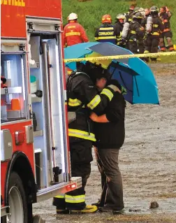  ?? PHOTO AGENCE QMI, STEVE POULIN ?? Des citoyens étaient réconforté­s par des pompiers après le drame survenu à Saint-Simon-les-Mines, en Beauce.