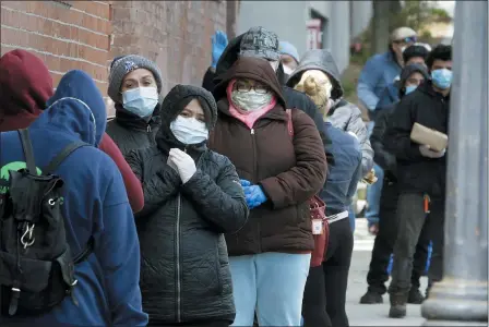  ?? THE ASSOCIATED PRESS ?? People wear protective masks out of concern for the coronaviru­s while standing in line outside a pop-up food pantry on April 16in Chelsea, Mass.