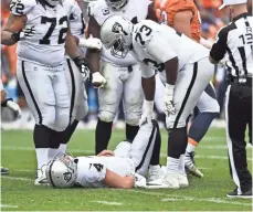  ?? RON CHENOY, USA TODAY SPORTS ?? The Raiders check on Derek Carr, who left because of spasms.