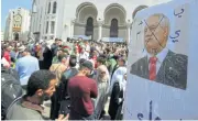  ?? /Reuters ?? Exit: A defaced picture of constituti­onal council chair Tayeb Belaiz carried by students who want Algeria’s ruling elite to go.