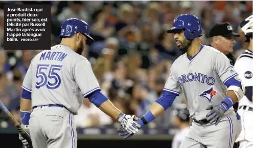  ?? PHOTO AFP ?? Jose Bautista qui a produit deux points, hier soir, est félicité par Russell Martin après avoir frappé la longue balle.