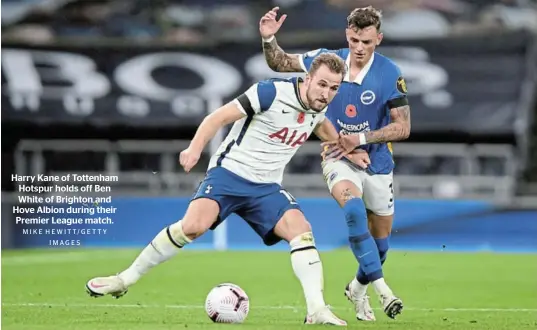  ?? M I K E H E W I T T/ GE T T Y I M AG E S ?? Harry Kane of Tottenham Hotspur holds off Ben White of Brighton and Hove Albion during their Premier League match.