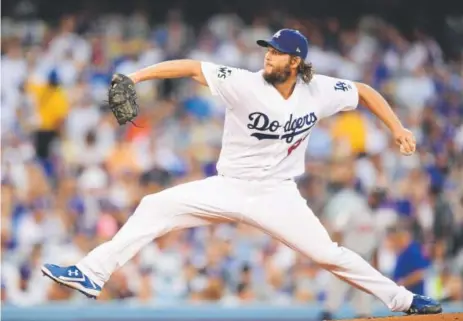  ?? Harry How, Getty Images ?? Los Angeles Dodgers ace Clayton Kershaw delivers a pitch during the first inning Tuesday night. Kershaw was brilliant, allowing three hits in seven innings, striking out 11 and walking none in winning Game 1 of the World Series.