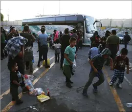  ?? MARCO UGARTE — THE ASSOCIATED PRESS ?? Migrants wait outside at an immigratio­n center on the Internatio­nal Bridge 1 to be bused recently from Nuevo Laredo to Monterrey, Mexico.