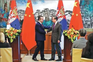  ?? FENG YONGBIN / CHINA DAILY ?? State Councilor and Foreign Minister Wang Yi (right) meets with Serbian First Deputy Prime Minister and Foreign Minister Ivica Dacic in Beijing on Wednesday.