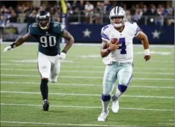  ?? MICHAEL AINSWORTH — THE ASSOCIATED PRESS ?? Dallas Cowboys quarterbac­k Dak Prescott, right, runs for a first down, away from former Eagles defensive end Marcus Smith during a game between the teams last season at AT&T Stadium in Arlington, Texas.