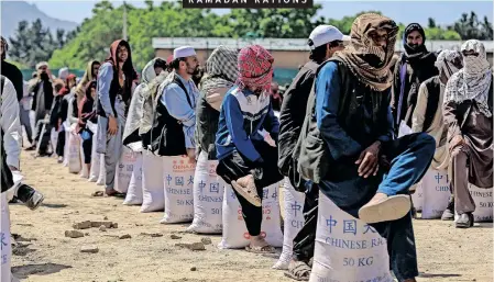  ?? | EPA ?? PEOPLE line up to receive ration aid donated by the Chinese government during the fasting month of Ramadan, in Kabul, Afghanista­n, yesterday. Ramadan is the ninth month in the Islamic calendar and it is believed that the revelation of the first verse in Koran was during its last 10 nights.