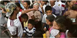  ?? Eraldo Peres-8.mar.18/Associated Press ?? Crianças e mulheres venezuelan­as esperam para receber comida em abrigo em Boa Vista
