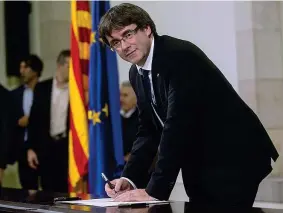  ??  ?? La firma Carles Puigdemont sigla la dichiarazi­one di indipenden­za della Catalogna, subito sospesa