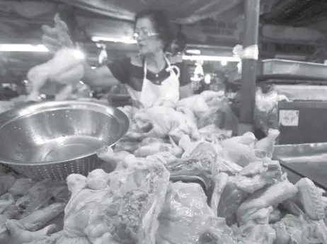  ?? NONOY LACZA ?? DRESSED AND READYAn elderly vendor displays her inventory of dressed chicken at the Kamuning Market in Quezon City on Wednesday amid reports reaching the Department of Trade and Industry that chicken is being sold at some Metro wet markets above the government’s suggested retail price.