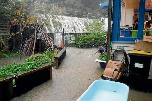  ??  ?? Children from Paremata Kindergart­en watch as water cascades into the grounds during Thursday’s deluge. Porirua was hit by 36mm in one hour, causing businesses, homes and schools to be evacuated. A perfect storm of warm seas, a fastmoving front and dry...