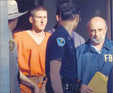  ?? John Gaps III
Associated Press ?? TIMOTHY McVEIGH is led from the Noble County Courthouse in 1995 after being identified as a suspect in the Oklahoma City bombing. A state trooper had arrested him for unlawfully carrying a concealed weapon.