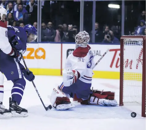  ?? JACK BOLAND ?? John Tavares tips the puck past Montreal Canadien Carey Price in his regular-season debut with the Maple Leafs in Toronto on Wednesday.