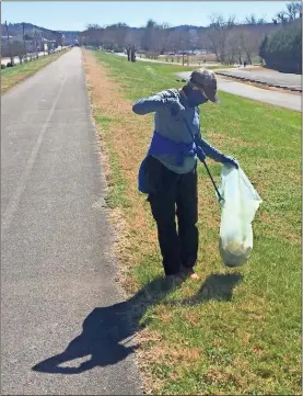  ?? Photos by Doug Walker and Olivia Morley ?? Above: Ball Corp. employee Mary Mcdonald picks up trash on top of the levee at Heritage Park on Wednesday afternoon.