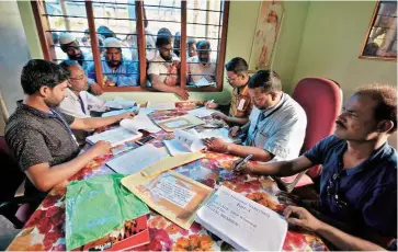  ?? REUTERS ?? People check their names on the draft list at the National Register of Citizens centre at a village in Nagaon district