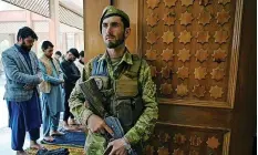  ??  ?? AN AFGHAN security officer stands guard as Muslim devotees offer prayers to start the Eidal-Fitr festival at a mosque in Kabul. | AFP