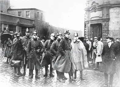  ?? TOPICAL PRESS AGENCY/GETTY ?? German police officers gather in a courtyard in January 1923 in Bochum, Germany. Some see ominous parallels between Germany in the 1920s and the United States in the current decade.