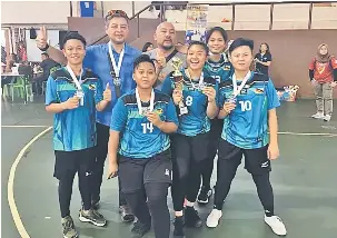  ??  ?? GEMBIRA: Pemain sepak takraw wanita Sarawak meraikan kejayaan bersama Sura (tengah) setelah muncul naib juara di Negeri Sembilan.