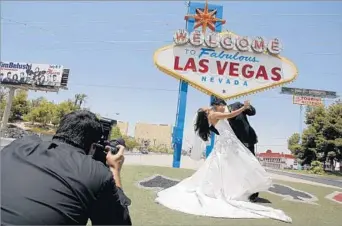  ?? Jae C. Hong
Associated Press ?? WORLD-FAMOUS LANDMARK A couple get married in 2007 by the “Welcome to Fabulous Las Vegas” sign. Its designer, Betty Willis, had little formal art training but was known for giving careful, detailed attention to every aspect of her signs.