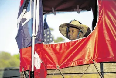  ?? Marie D. De Jesús / Staff photograph­er ?? A child keeps an eye on the road as the Prairie View Trail Ride arrives at the Community of Faith Church.