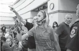  ?? BIZUAYEHU TESFAYE/LAS VEGAS REVIEW-JOURNAL ?? Disruptive protesters against a COVID-19 mandate are escorted out of a Clark County School Board meeting Aug. 12 in Las Vegas.