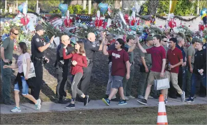  ?? AP PHOTO ?? Students are greeted by law enforcemen­t as they head back to school at Marjory Stoneman Douglas High School on Wednesday.