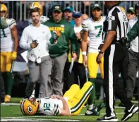  ?? AP PHOTO BRUCE KLUCKHOHN ?? Green Bay Packers quarterbac­k Aaron Rodgers (12) lies on the ground after being hit by Minnesota Vikings outside linebacker Anthony Barr (55) in the first half of an NFL football game in Minneapoli­s, Sunday.