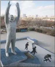  ?? (AP/Dmitri Lovetsky) ?? Children play near a sculpture of Gagarin at the Russian-leased Baikonur cosmodrome — the world’s first and largest operationa­l space launch facility — in Baikonur, Kazakhstan.