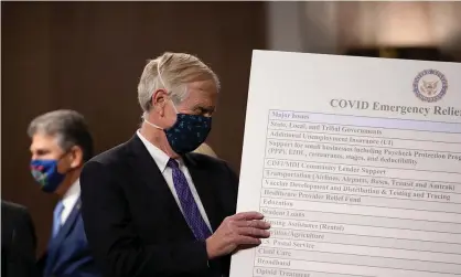  ??  ?? Senator Angus King sets up a sign as a bipartisan group argues for a Covid-19 relief bill on Capitol Hill in December 2020. Photograph: Tasos Katopodis/Getty Images