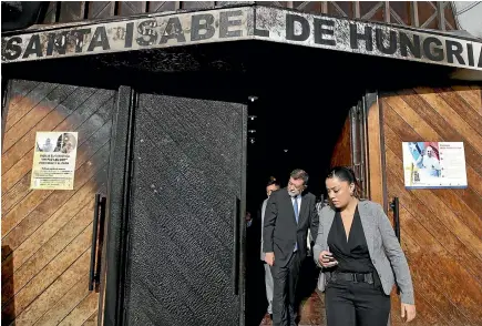  ?? AP ?? Chilean Deputy Interior Secretary Aleuy Mahmud and his staff leave the Santa Isabel de Hungria Catholic Church in Santiago yesterday after inspecting the damage from a firebomb attack. Vandals firebombed three churches in the Chilean capital ahead of a...