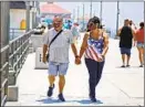  ?? Raul Roa Los Angeles Times ?? DANNY LOPEZ and Frances Pluma stroll on the pier in Huntington Beach.