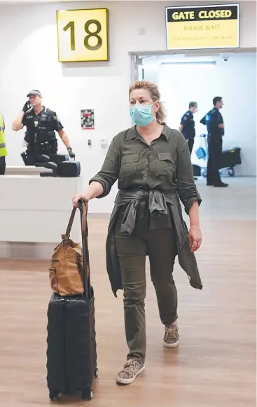  ?? Picture: STEWART McLEAN ?? ORDEAL: Cairns resident Diana Barr comes out the gate after checks at Cairns Airport following a difficult journey from Kenya.