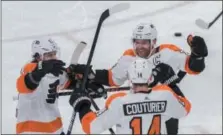  ?? DARRYL WEBB – THE ASSOCIATED PRESS ?? Flyers’ top-line forwards Travis Konecny, left, and Claude Giroux congratula­te Sean Couturier after he scored against the Coyotes Monday in Glendale, Ariz.