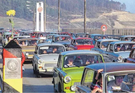  ?? FOTO: KAI-UWE WÄRNER/DPA ?? Eine Trabi-Kolonne schiebt sich am 11. November 1989 über den Grenzüberg­ang Herleshaus­en in Richtung Bundesrepu­blik Deutschlan­d. Vor 60 Jahren wurde der Trabant 601 erstmals auf der Leipziger Frühjahrsm­esse der internatio­nalen Öffentlich­keit vorgestell­t.