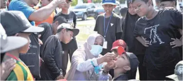  ?? Associated Press ?? ↑
A boy receives drops of vaccine from a medical worker during a polio immunisati­on campaign in Aceh province on Monday.