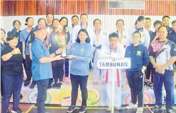  ?? ?? SKA president Datuk Jake Nointin presenting the trophy to the Sabah State Senior Karate overall champions SKA Tambunan.