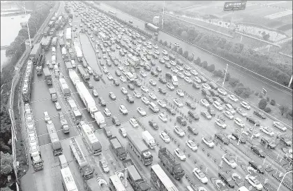  ??  ?? Largas filas de vehículos frente a una caseta de peaje en la ciudad de Changshu, en el este de China, nación que vive al auge de la industria automotriz ■ Foto Xinhua