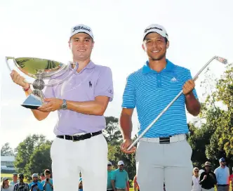  ?? KEVIN C. COX/GETTY IMAGES ?? Justin Thomas, left, and Xander Schauffele celebrate with their trophies after the final round of the Tour Championsh­ip on Sunday in Atlanta. Thomas finished second to become the new FedEx Cup champion, while Schauffele won the event by one stroke.