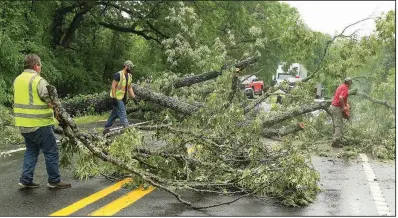  ?? The Sentinel-Record/RICHARD RASMUSSEN ?? Workers in Garland County clear away an oak tree that toppled Wednesday in the 800 block of Arkansas 128 near Millcreek Road in Fountain Lake.