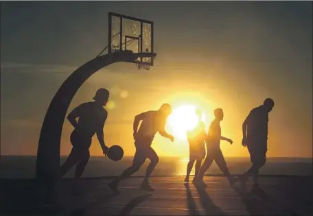  ?? Genaro Molina Los Angeles Times ?? MEN PLAY basketball on an 88-degree day this month in San Pedro. Experts say 2021 was the fourth-hottest year on record in the U.S.