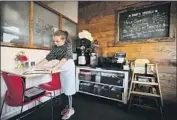  ?? Francine Orr Los Angeles Times ?? VIOLET HALLET, 10, cleans menus last month at Flore Vegan, her mother’s restaurant in Silver Lake.