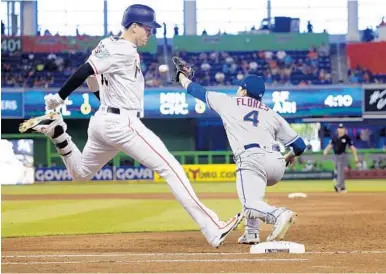  ?? CARL JUSTE/MIAMI HERALD ?? The ball and Miami Marlins’ Brian Anderson arrive at first base almost at the same time on this play Sunday against the Mets. New York first baseman Wilmer Flores did get the ball first and Anderson was called out on this close play.