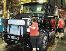  ?? JEFF GUERINI / STAFF ?? Navistar Internatio­nal employees put together a truck on the assembly line.