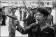  ?? CHRISTOPH FROEHDER — THE ASSOCIATED PRESS ?? A Khmer Rouge soldier waves his pistol and orders store owners to abandon their shops in Phnom Penh, Cambodia, on April 17,
1975 as the capital fell to the communist forces. A large portion of the city’s population was reportedly forced to evacuate.
Photo from West German television film.