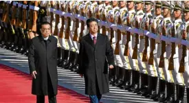  ?? —AFP ?? HISTORIC MOMENT Chinese Premier Li Keqiang (left) accompanie­s Japan Prime Minister Shinzo Abe in trooping a military honor guard in Beijing on Oct. 26.