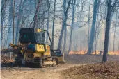  ?? DANIEL LIN/AP ?? A Virginia Department of Forestry bulldozer cuts a fire line during a wildfire in Bergton.